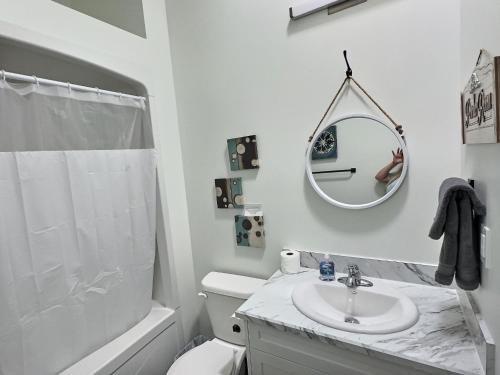 a white bathroom with a sink and a mirror at Summer Suite - Pet Friendly in Brandon