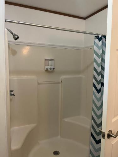 a shower with a glass door in a bathroom at Aaron’s cottage in Hilo
