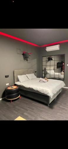 um quarto com uma cama grande com uma faixa vermelha por cima em Jentelmen rooms em Haifa