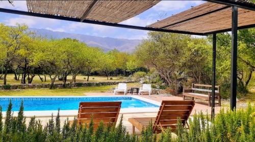 una piscina in un cortile con sedie e una piscina di Complejo Cabañas La Aguada a La Población