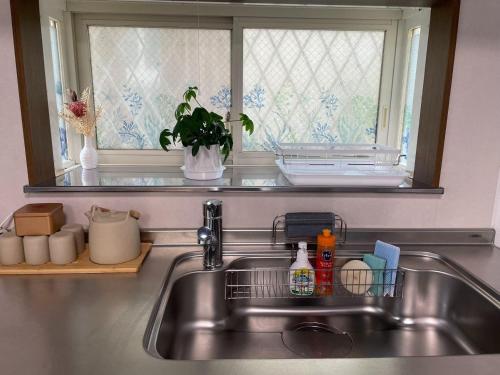a kitchen sink with a dish drying rack next to a window at Enoshima HOME2 - Vacation STAY 20227v in Fujisawa