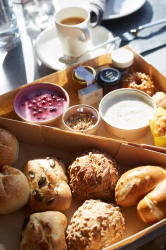 a box filled with different types of pastries and a cup of coffee at Alpenstolz Damüls Haus 4 - Stilvoll urlauben in den Bergen in Damuls