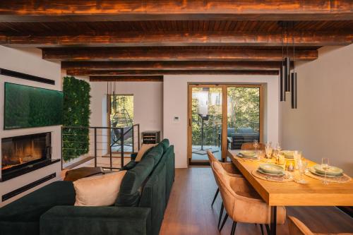 a living room with a dining table and a fireplace at The Magic Forest - Holiday Home & Spa Zone Platak in Soboli