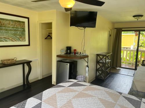 a bedroom with a bed and a television on the wall at Aaron’s cottage in Hilo