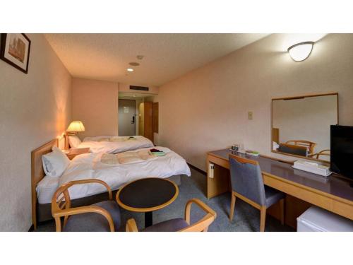 a hotel room with a bed and a desk and a mirror at Yuuai Kumanokan - Vacation STAY 27598v in Matsue