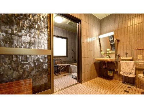 a bathroom with a sink and a toilet and a mirror at Yuuai Kumanokan - Vacation STAY 27598v in Matsue