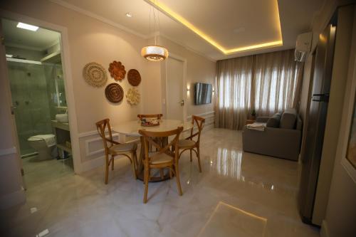 a kitchen and living room with a table and chairs at Flat Beira Mar in Fortaleza