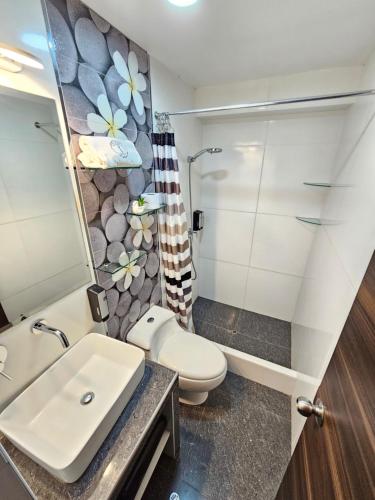 a bathroom with a toilet and a sink at EL FARO HOTEL in Chala