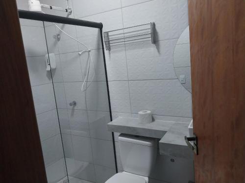uma casa de banho com um chuveiro, um WC e um lavatório. em Hotel-Pousada Quartzo Rosa em São Tomé das Letras
