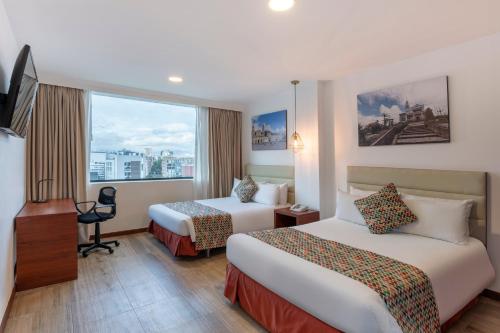 a hotel room with two beds and a window at Hotel Andes Plaza in Bogotá