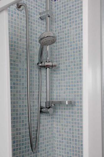 a shower in a bathroom with blue tiles at Dei Meravigli in Bari