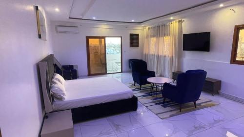 達喀爾的住宿－BI HOTEL 2，卧室配有一张床和一张桌子及椅子