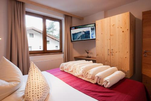 ein Schlafzimmer mit einem Bett und einem TV an der Wand in der Unterkunft Falkner Appartement Resort in Längenfeld