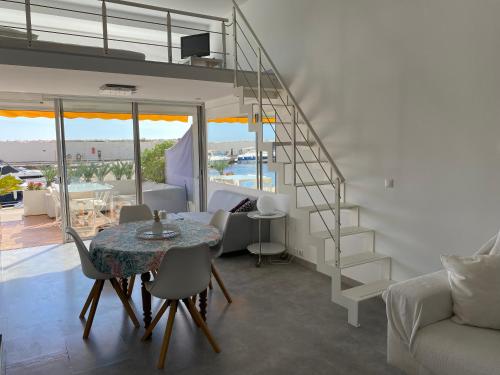 un salon avec une table et un escalier en colimaçon dans l'établissement Duplex face à la mer ATHENA PORT, à Bandol