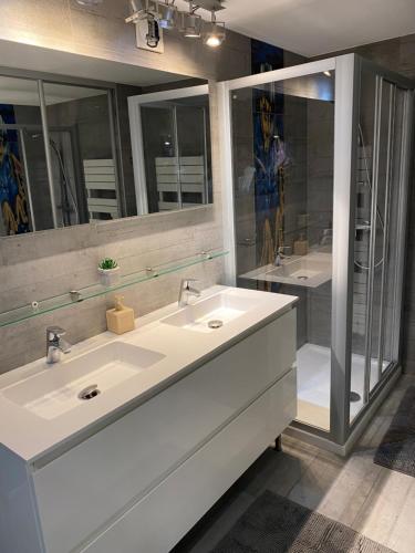 une salle de bain avec deux lavabos et un grand miroir dans l'établissement Duplex face à la mer ATHENA PORT, à Bandol