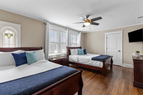 1 dormitorio con 2 camas y ventilador de techo en Elegant Family Retreat - JZ Vacation Rentals, en Tower Grove