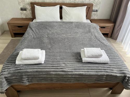 a large bed with two towels on top of it at Готель «У Батька» in Truskavets