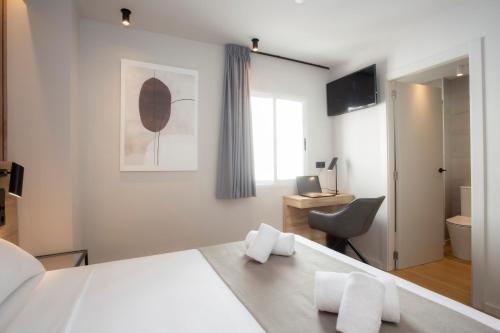 una camera con letto, scrivania e sedia di Aila II Hotel Boutique by SingularStays - Digital Access a Burjassot