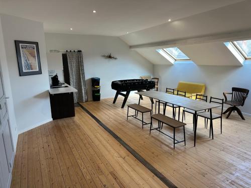 a room with a table and chairs and a piano at Appartement 160m2 - 2e étage maison de maître in Beaupréau
