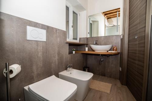 a bathroom with a white toilet and a sink at Tenuta il Giardino in Capannori