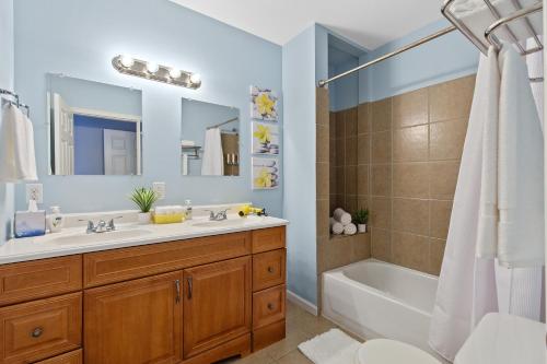 uma casa de banho com um lavatório, uma banheira e um chuveiro em Exquisitely Designed Townhome - JZ Vacation Rentals em Saint Louis