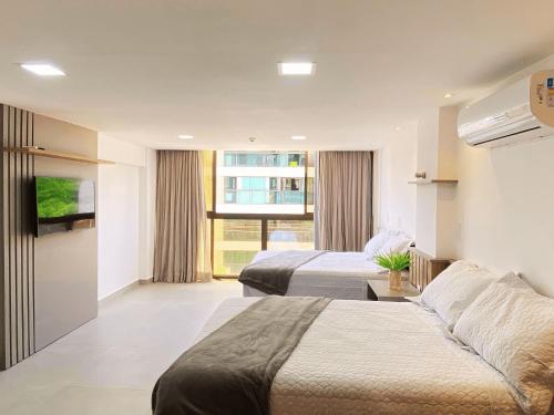 a hotel room with two beds and a window at FM20 CABO BRANCO Stilo - By Almare Flats in João Pessoa