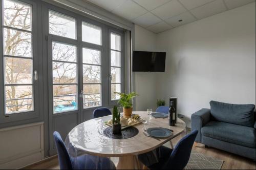uma sala de estar com uma mesa e cadeiras e um sofá em Résidence Harmonie Appartement N 3 Meublé Avec Petit Déjeuner em Néris-les-Bains