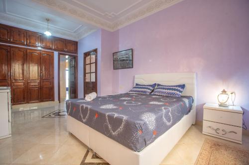 a bedroom with a bed and a purple wall at Villa en pleine campagne avec vue sur l'atlas in Marrakech