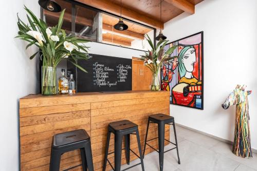 a bar with two stools and a chalkboard at Hostal Juarez in Mexico City