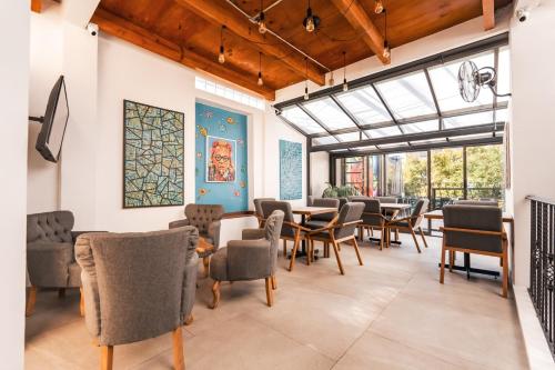 a dining room with chairs and tables and windows at Hostal Juarez in Mexico City