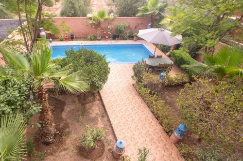 an overhead view of a swimming pool with an umbrella at Villa en pleine campagne avec vue sur l'atlas in Marrakech