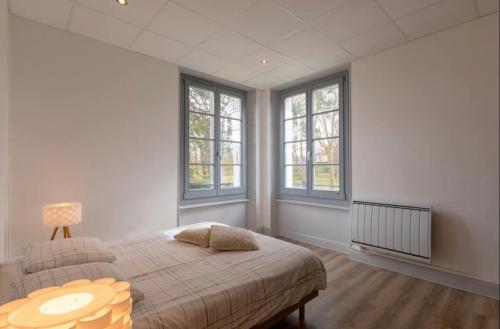 1 dormitorio con 1 cama, mesa y ventanas en Résidence Harmonie Appartement N 3 Meublé Avec Petit Déjeuner, en Néris-les-Bains