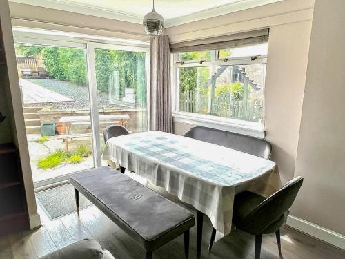 a dining room with a table and chairs and a window at Immanuel House - Modern Luxury Victorian Home 1872 - Free Parking & SuperFast Fibre Optic WiFi in Edinburgh