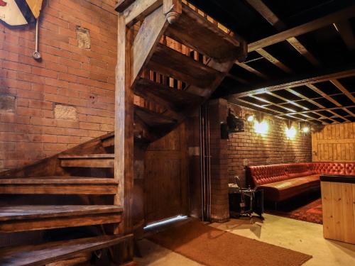 a large room with a brick wall and a staircase at Fernhill Castle in Keighley