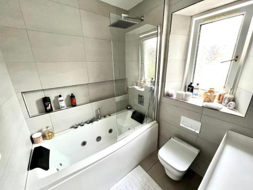 a bathroom with a tub and a toilet and a sink at Immanuel House - Modern Luxury Victorian Home 1872 - Free Parking & SuperFast Fibre Optic WiFi in Edinburgh