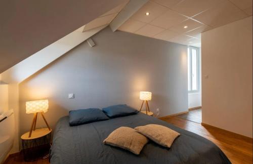 ein Schlafzimmer mit einem großen Bett mit zwei Lampen in der Unterkunft Logement N 5 haut de gamme Neris Les Bains Avec Petit Déjeuner in Néris-les-Bains