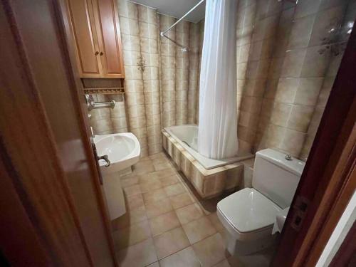 a small bathroom with a toilet and a sink at Apartamento DENTRO DE MURALLA y PARKING GRATUITO en pleno centro in Lugo