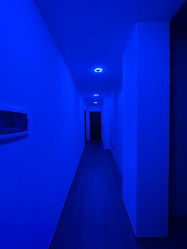 een donkere kamer met een blauw licht en een deur bij Green Apartment in Pioltello