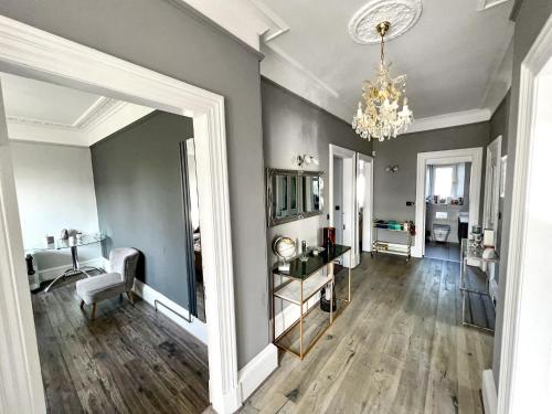 een woonkamer met een spiegel en een kroonluchter bij Immanuel House - Modern Victorian Home 1872 - Free Parking & Fast Fibre Optic WiFi in Edinburgh