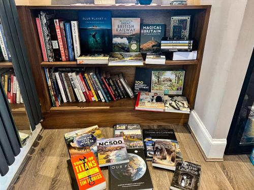 a book shelf full of books on the floor at Immanuel House - Modern Luxury Victorian Home 1872 - Free Parking & SuperFast Fibre Optic WiFi in Edinburgh
