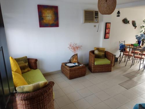 sala de estar con sillas de mimbre y mesa en Casa Vía Spondylus, en Santa Elena