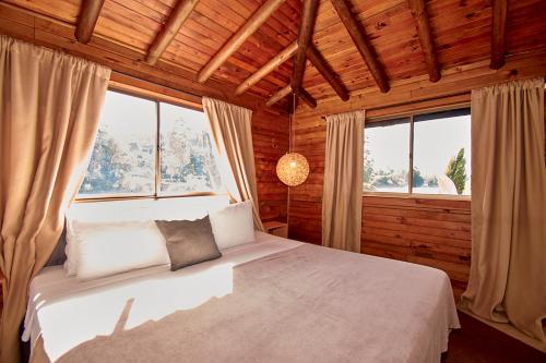 una camera da letto con un letto in una stanza con finestre di Mansión by Bernalo Hotels a Guatapé