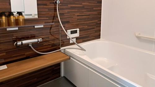 eine Badewanne mit einem Schlauch, der an ein Waschbecken angeschlossen ist in der Unterkunft Guest House Jino - Vacation STAY 15446 in Takayama