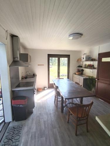 une cuisine avec une table en bois et une salle à manger dans l'établissement Châlet 8 personnes + grand terrain et rivière, à Entremont