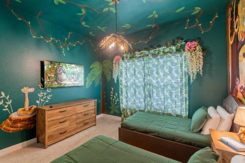 Cette chambre pour enfants dispose d'un mur vert orné d'une fresque murale représentant les arbres. dans l'établissement Amazing Thematic House Pvt PoolArcades Resort, à Orlando