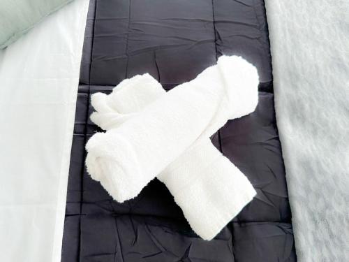 um par de toalhas brancas deitadas numa cama em Tiam Anh-TiAM CONCIERGERIE DISNEY Maison PARKING Gratuit em Bailly-Romainvilliers