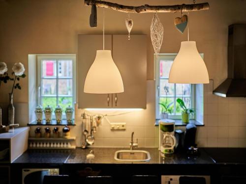 una cocina con dos luces colgantes y un lavabo en Located 10km from Maastricht towards the Belgium border, en Eijsden