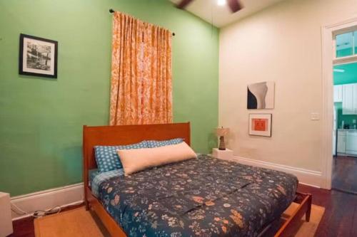 1 dormitorio con 1 cama en una pared verde en Jazzy vibrant getaway Hot Tub Cabana 1517, en Nueva Orleans