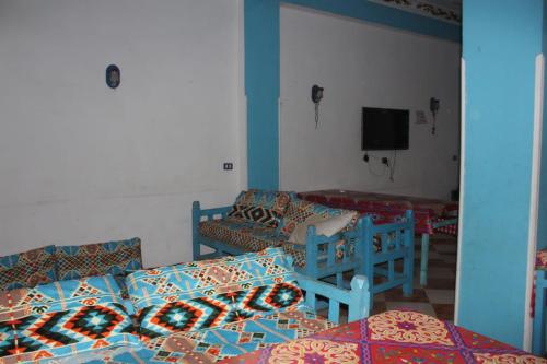 um quarto com duas camas e uma tv nele em Djorf apartments em Al Aqālitah