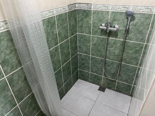 a bathroom with a shower with green tile at Готель «У Батька» in Truskavets